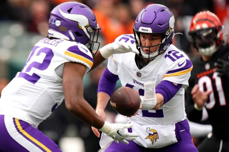 Dec 16, 2023; Cincinnati, Ohio, USA; Minnesota Vikings quarterback Nick Mullens (12) hands the ball off to Minnesota Vikings running back Ty Chandler (32) in the first quarter of the game against the Cincinnati Bengals at Paycor Stadium. Mandatory Credit: Kareem Elgazzar/The Enquirer-USA TODAY Sports
