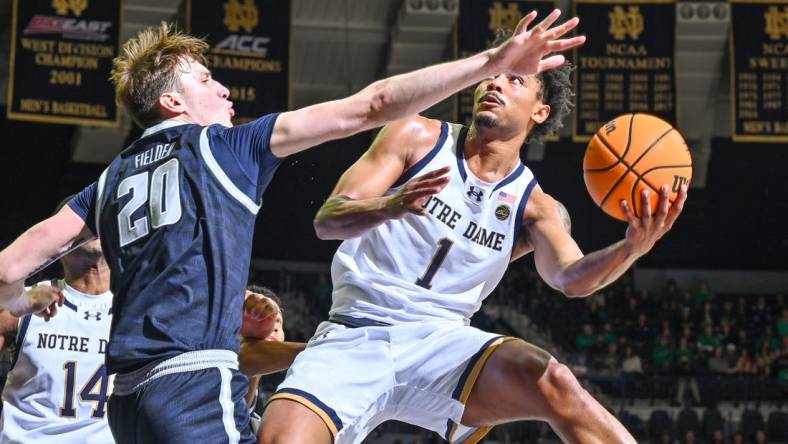 Dec 16, 2023; South Bend, Indiana, USA; Notre Dame Fighting Irish guard Julian Roper II (1) goes up for a shot as Georgetown Hoyas forward Drew Fielder (20) defends in the first half at the Purcell Pavilion. Mandatory Credit: Matt Cashore-USA TODAY Sports