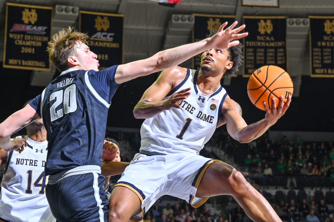Dec 16, 2023; South Bend, Indiana, USA; Notre Dame Fighting Irish guard Julian Roper II (1) goes up for a shot as Georgetown Hoyas forward Drew Fielder (20) defends in the first half at the Purcell Pavilion. Mandatory Credit: Matt Cashore-USA TODAY Sports