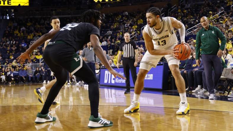 Dec 16, 2023; Ann Arbor, Michigan, USA; Michigan Wolverines forward Olivier Nkamhoua (13) is defended by Eastern Michigan Eagles forward Yusuf Jihad (22) in the first half at Crisler Center. Mandatory Credit: Rick Osentoski-USA TODAY Sports