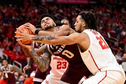 Dec 16, 2023; Houston, Texas, USA; Texas A&M Aggies guard Jace Carter (0) is blocked by Houston Cougars guard Emanuel Sharp (21) during the first half at Toyota Center. Mandatory Credit: Maria Lysaker-USA TODAY Sports