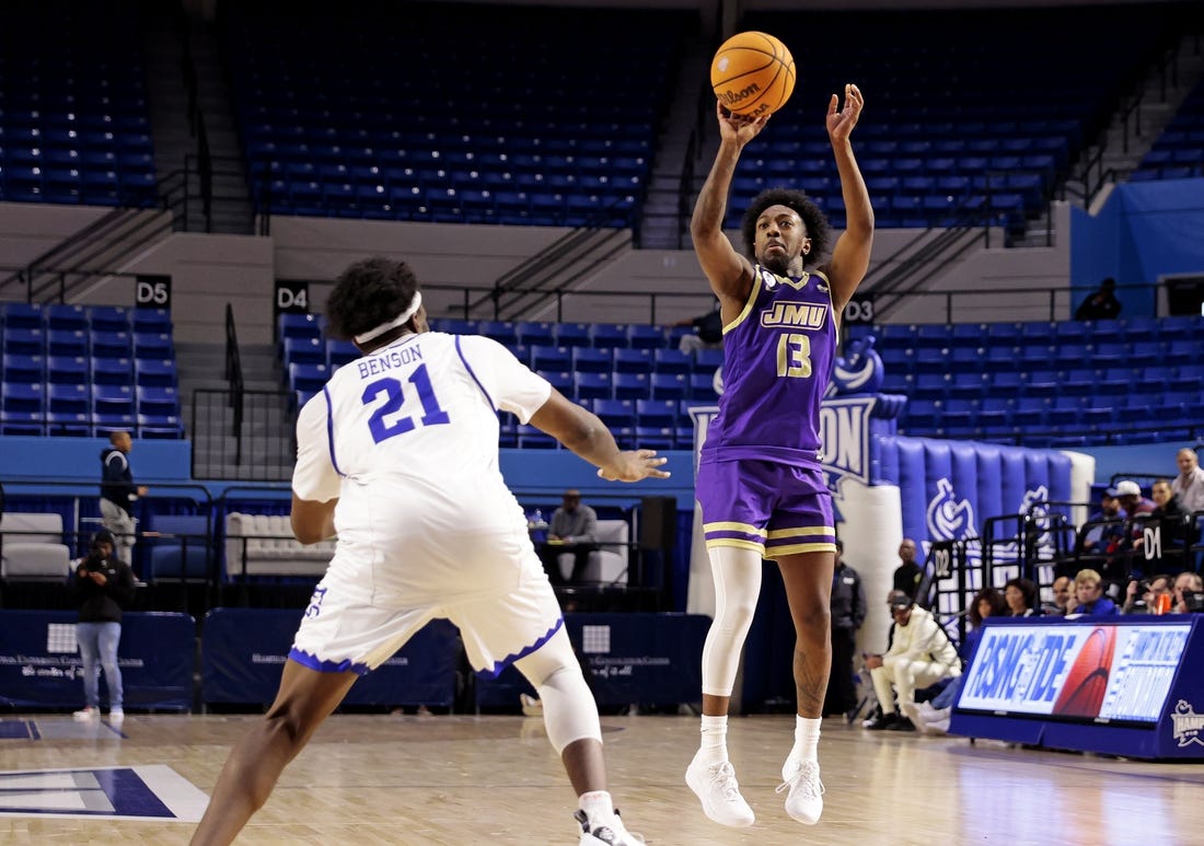 Dec 16, 2023; Hampton, Virginia, USA; James Madison Dukes guard Michael Green III (13) shoots the ball against Hampton Pirates forward Ja'Von Benson (21) during the second half at Hampton Convocation Center. Mandatory Credit: Peter Casey-USA TODAY Sports