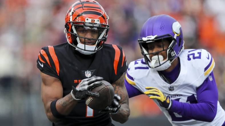 Dec 16, 2023; Cincinnati, Ohio, USA; Cincinnati Bengals wide receiver Ja'Marr Chase (1) runs with the ball against Minnesota Vikings cornerback Akayleb Evans (21) in the first half at Paycor Stadium. Mandatory Credit: Katie Stratman-USA TODAY Sports