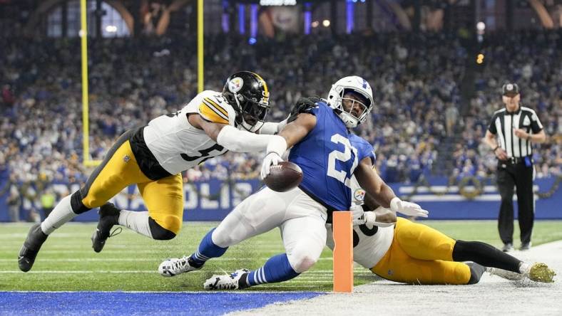 Dec 16, 2023; Indianapolis, Indiana, USA; Indianapolis Colts running back Zack Moss (21) slides into the end zone for a touchdown while being chased by Pittsburgh Steelers linebacker Elandon Roberts (50) and Pittsburgh Steelers linebacker Mykal Walker (38) during a game against the Pittsburgh Steelers at Lucas Oil Stadium. Mandatory Credit: Robert Scheer-USA TODAY Sports