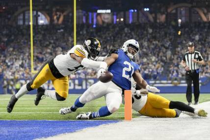 Dec 16, 2023; Indianapolis, Indiana, USA; Indianapolis Colts running back Zack Moss (21) slides into the end zone for a touchdown while being chased by Pittsburgh Steelers linebacker Elandon Roberts (50) and Pittsburgh Steelers linebacker Mykal Walker (38) during a game against the Pittsburgh Steelers at Lucas Oil Stadium. Mandatory Credit: Robert Scheer-USA TODAY Sports