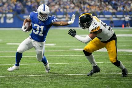 Indianapolis Colts running back Tyler Goodson (31) reaches to stiff arm Pittsburgh Steelers linebacker Elandon Roberts (50) as he rushes toward the end zone Saturday, Dec. 16, 2023, during a game against the Pittsburgh Steelers at Lucas Oil Stadium in Indianapolis.