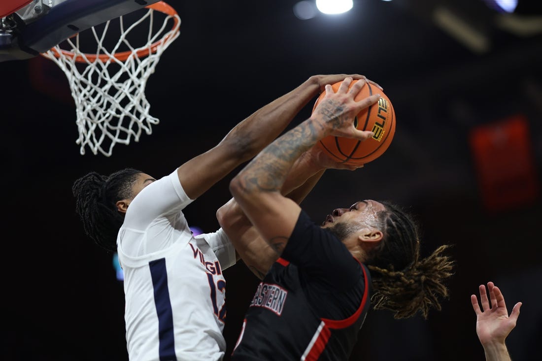 Dec 16, 2023; Charlottesville, Virginia, USA; Virginia Cavaliers guard Elijah Gertrude (12) blocks the shot of Northeastern Huskies guard Joe Pridgen (0) in the first half at John Paul Jones Arena. Mandatory Credit: Geoff Burke-USA TODAY Sports