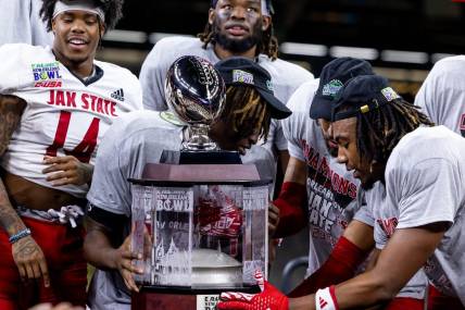 Dec 16, 2023; New Orleans, LA, USA;  Jacksonville State Gamecocks hold up the game trophy after the game against the Louisiana-Lafayette Ragin Cajuns at the Caesars Superdome. Mandatory Credit: Stephen Lew-USA TODAY Sports