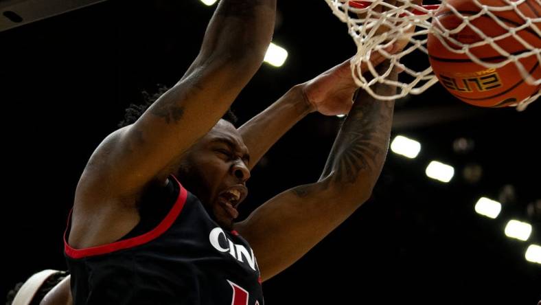 Cincinnati Bearcats forward Jamille Reynolds (13) dunks around Dayton Flyers forward DaRon holmes II (15) in the first half of the NCAA men's basketball game between the Dayton Flyers and Cincinnati Bearcats at Heritage Bank Center in Cincinnati on Saturday, Dec. 16, 2023.