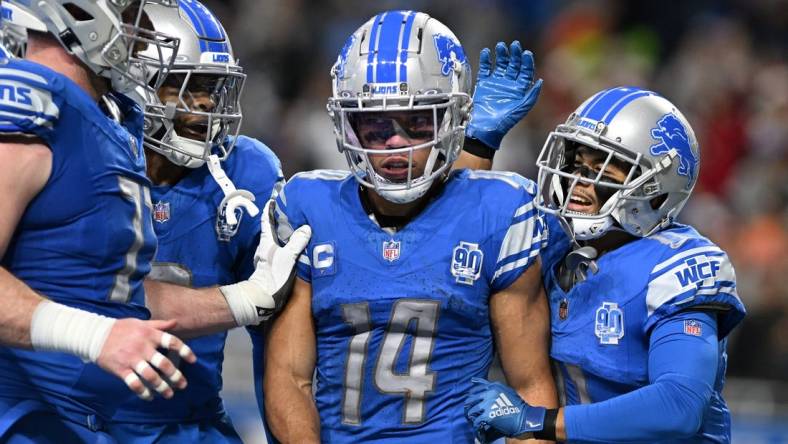 Dec 16, 2023; Detroit, Michigan, USA; Detroit Lions wide receiver Amon-Ra St. Brown (14) celebrates in the end zone with wide receiver Kalif Raymond (right) and wide receiver Jameson Williams (9) and center Frank Ragnow (left) after scoring a touchdown against the Denver Broncos in the second quarter at Ford Field. Mandatory Credit: Lon Horwedel-USA TODAY Sports