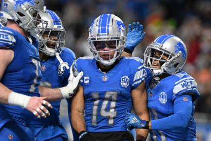 Dec 16, 2023; Detroit, Michigan, USA; Detroit Lions wide receiver Amon-Ra St. Brown (14) celebrates in the end zone with wide receiver Kalif Raymond (right) and wide receiver Jameson Williams (9) and center Frank Ragnow (left) after scoring a touchdown against the Denver Broncos in the second quarter at Ford Field. Mandatory Credit: Lon Horwedel-USA TODAY Sports