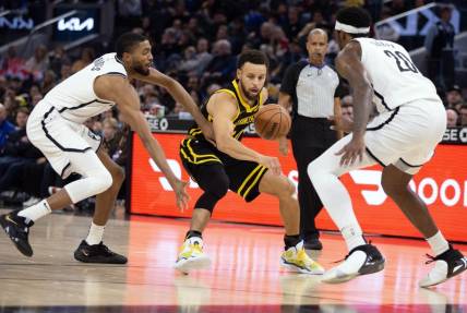 Dec 16, 2023; San Francisco, California, USA; Golden State Warriors guard Stephen Curry (30) controls the ball against Brooklyn Nets guard Mikal Bridges (1) and center Day'Ron Sharpe (20) during the second quarter at Chase Center. Mandatory Credit: D. Ross Cameron-USA TODAY Sports