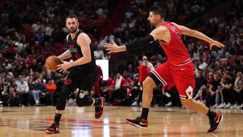 Dec 16, 2023; Miami, Florida, USA; Miami Heat forward Kevin Love (42) dribbles the ball around Miami Heat guard Dru Smith (9) during the second half at Kaseya Center. Mandatory Credit: Jasen Vinlove-USA TODAY Sports