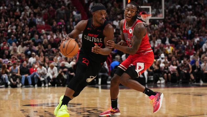 Dec 16, 2023; Miami, Florida, USA; Miami Heat forward Jimmy Butler (22) drives the ball around Chicago Bulls guard Ayo Dosunmu (12) during the second half at Kaseya Center. Mandatory Credit: Jasen Vinlove-USA TODAY Sports