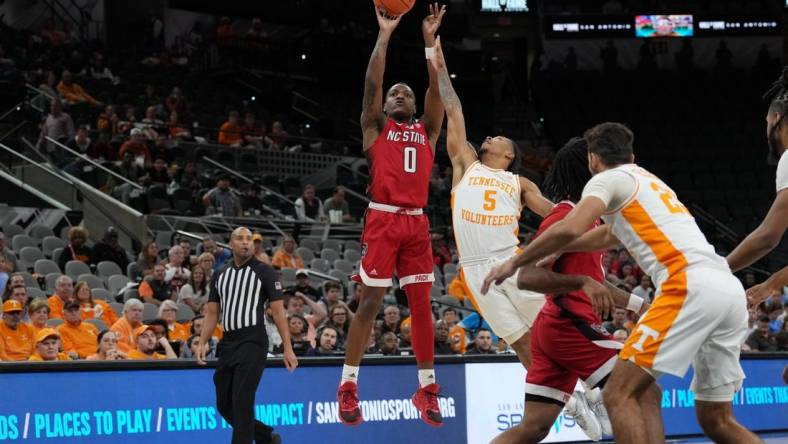 Dec 16, 2023; San Antonio, Texas, USA;  North Carolina State Wolfpack guard DJ Horne (0) shoots over Tennessee Volunteers guard Zakai Zeigler (5) in the first half at the Frost Bank Center. Mandatory Credit: Daniel Dunn-USA TODAY Sports