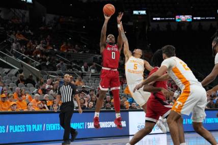 Dec 16, 2023; San Antonio, Texas, USA;  North Carolina State Wolfpack guard DJ Horne (0) shoots over Tennessee Volunteers guard Zakai Zeigler (5) in the first half at the Frost Bank Center. Mandatory Credit: Daniel Dunn-USA TODAY Sports