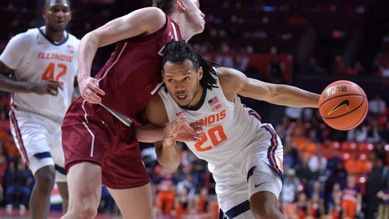 Dec 17, 2023; Champaign, Illinois, USA;  Illinois Fighting Illini forward Ty Rodgers (20) drives the ball against Colgate Raiders guard Brady Cummins (1) during the first half at State Farm Center. Mandatory Credit: Ron Johnson-USA TODAY Sports