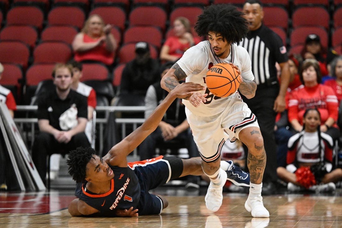 Dec 17, 2023; Louisville, Kentucky, USA;  Louisville Cardinals guard Skyy Clark (55) dribbles against Pepperdine Waves guard Michael Ajayi (1) during the second half at KFC Yum! Center. Louisville defeated Pepperdine 85-63. Mandatory Credit: Jamie Rhodes-USA TODAY Sports