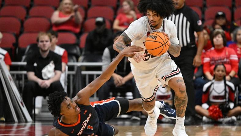 Dec 17, 2023; Louisville, Kentucky, USA;  Louisville Cardinals guard Skyy Clark (55) dribbles against Pepperdine Waves guard Michael Ajayi (1) during the second half at KFC Yum! Center. Louisville defeated Pepperdine 85-63. Mandatory Credit: Jamie Rhodes-USA TODAY Sports