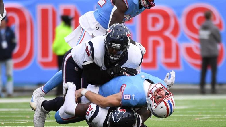 Dec 17, 2023; Nashville, Tennessee, USA; Tennessee Titans quarterback Will Levis (8) is injured after being sacked by Houston Texans cornerback Desmond King II (25) defensive tackle Sheldon Rankins (98) in overtime at Nissan Stadium. Mandatory Credit: Christopher Hanewinckel-USA TODAY Sports