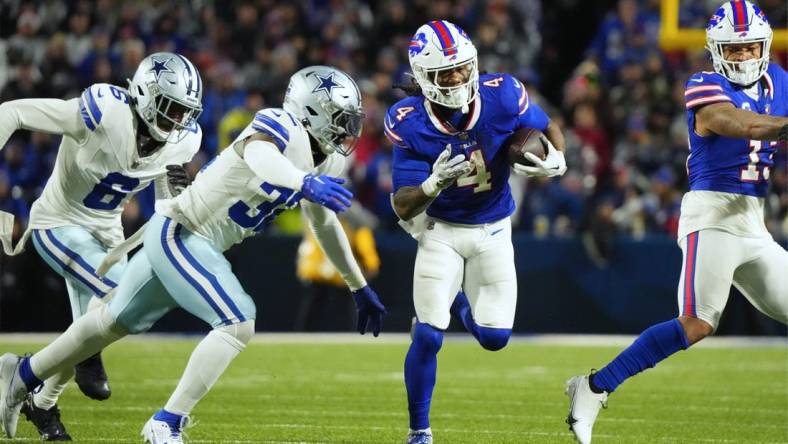 Dec 17, 2023; Orchard Park, New York, USA; Buffalo Bills running back James Cook (4) runs the ball pressured by Dallas Cowboys linebacker Rashaan Evans (32) in the first half at Highmark Stadium. Mandatory Credit: Gregory Fisher-USA TODAY Sports