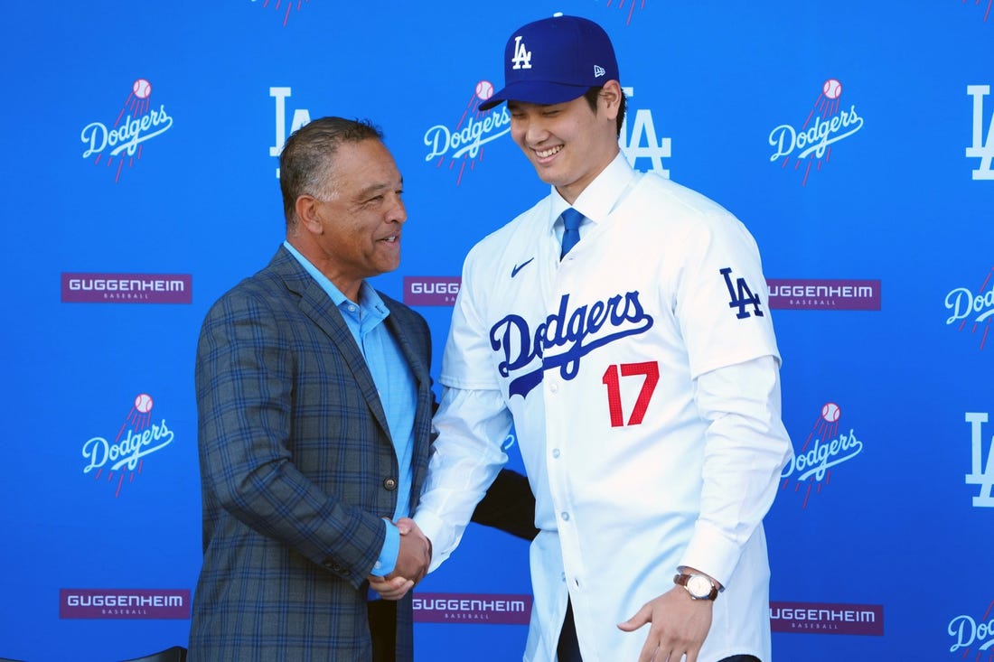 Dec 14, 2023; Los Angeles, CA, USA; Los Angeles Dodgers designated hitter Shohei Ohtani (17) shakes hands with manager Dave Roberts at press conference at Dodger Stadium. Mandatory Credit: Kirby Lee-USA TODAY Sports