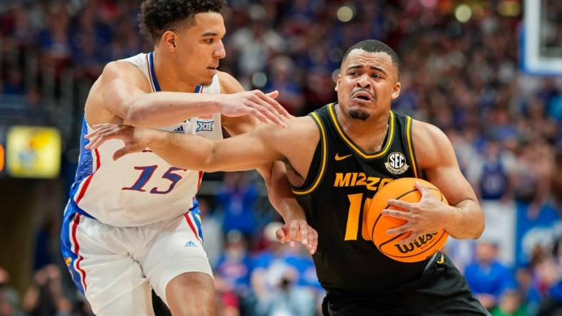 Dec 9, 2023; Lawrence, Kansas, USA; Missouri Tigers guard Nick Honor (10) drives against Kansas Jayhawks guard Kevin McCullar Jr. (15) during the first half at Allen Fieldhouse. Mandatory Credit: Jay Biggerstaff-USA TODAY Sports