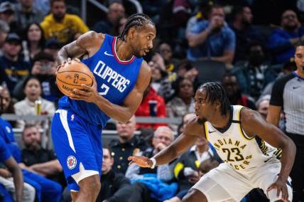 Dec 18, 2023; Indianapolis, Indiana, USA;  LA Clippers forward Kawhi Leonard (2) holds the ball while Indiana Pacers forward Aaron Nesmith (23) defends in the second half at Gainbridge Fieldhouse. Mandatory Credit: Trevor Ruszkowski-USA TODAY Sports