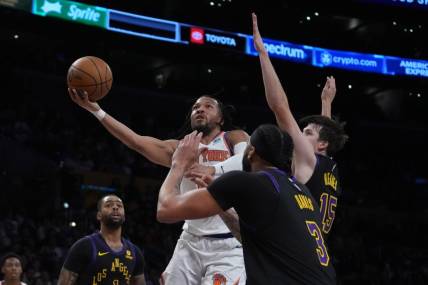 Dec 18, 2023; Los Angeles, California, USA; New York Knicks guard Immanuel Quickley (5) shoots the ball against Los Angeles Lakers guard D'Angelo Russell (1), forward Anthony Davis (3) and guard Austin Reaves (15) in the first half at Crypto.com Arena. Mandatory Credit: Kirby Lee-USA TODAY Sports