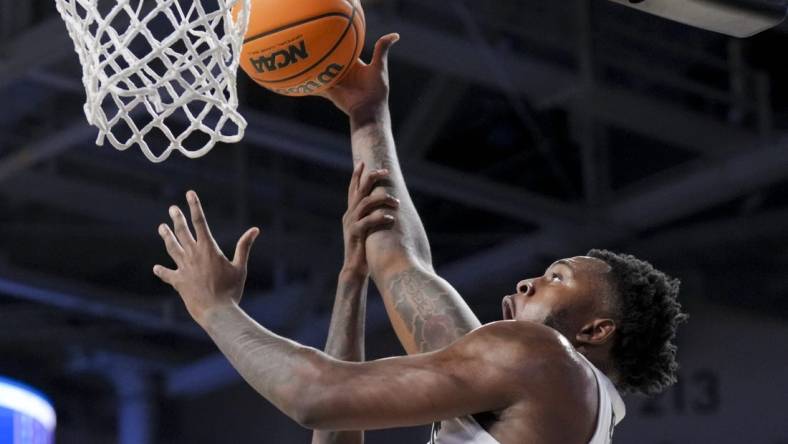 Dec 19, 2023; Cincinnati, Ohio, USA; Cincinnati Bearcats forward Jamille Reynolds (13) attempts a dunk as he is fouled by Merrimack Warriors guard Devon Savage (5) in the first half at Fifth Third Arena. Mandatory Credit: Aaron Doster-USA TODAY Sports