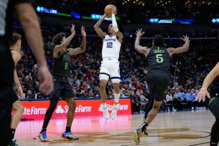Dec 19, 2023; New Orleans, Louisiana, USA;  Memphis Grizzlies guard Ja Morant (12) shoots in between New Orleans Pelicans forwards Naji Marshall (8) and Herbert Jones (5) during the second quarter at the Smoothie King Center. Mandatory Credit: Matthew Hinton-USA TODAY Sports