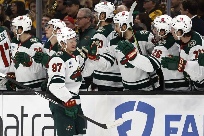 Dec 19, 2023; Boston, Massachusetts, USA; Minnesota Wild left wing Kirill Kaprizov (97) smiles as he is congratulated at the bench after scoring against the Boston Bruins during the third period at TD Garden. Mandatory Credit: Winslow Townson-USA TODAY Sports