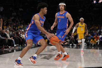 Dec 19, 2023; Charlotte, North Carolina, USA; Florida Gators guard Zyon Pullin (0) handles the ball watched by guard Walter Clayton Jr. (1) during the second half against the Michigan Wolverines at Spectrum Center. Mandatory Credit: Jim Dedmon-USA TODAY Sports