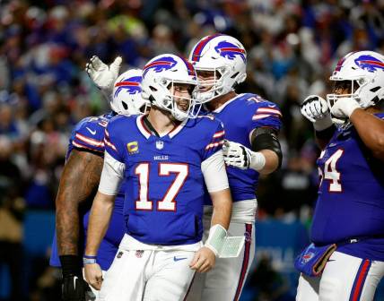 Bills quarterback Josh Allen (17) celebrates with teammates after scoring on a rushing touchdown against the Cowboys.