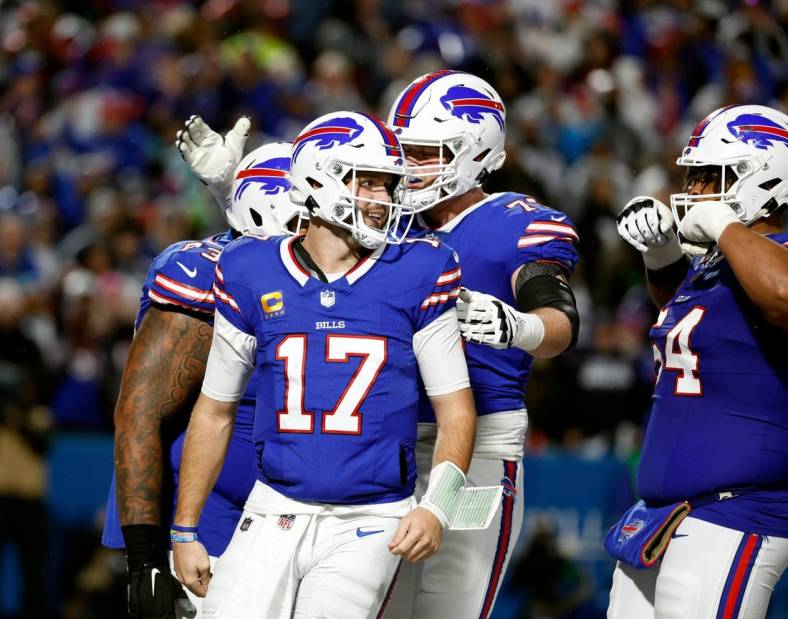 Bills quarterback Josh Allen (17) celebrates with teammates after scoring on a rushing touchdown against the Cowboys.