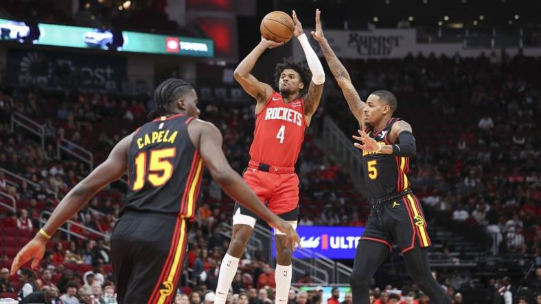 Dec 20, 2023; Houston, Texas, USA; Houston Rockets guard Jalen Green (4) shoots the ball as Atlanta Hawks guard Dejounte Murray (5) defends during the first quarter at Toyota Center. Mandatory Credit: Troy Taormina-USA TODAY Sports