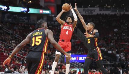 Dec 20, 2023; Houston, Texas, USA; Houston Rockets guard Jalen Green (4) shoots the ball as Atlanta Hawks guard Dejounte Murray (5) defends during the first quarter at Toyota Center. Mandatory Credit: Troy Taormina-USA TODAY Sports