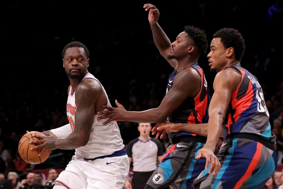 Dec 20, 2023; Brooklyn, New York, USA; New York Knicks forward Julius Randle (30) controls the ball against Brooklyn Nets forward Dorian Finney-Smith (28) and center Nic Claxton (33) during the first quarter at Barclays Center. Mandatory Credit: Brad Penner-USA TODAY Sports