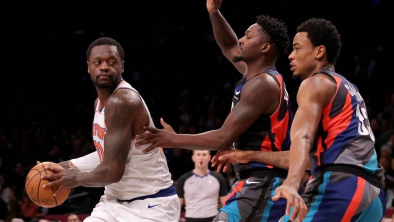 Dec 20, 2023; Brooklyn, New York, USA; New York Knicks forward Julius Randle (30) controls the ball against Brooklyn Nets forward Dorian Finney-Smith (28) and center Nic Claxton (33) during the first quarter at Barclays Center. Mandatory Credit: Brad Penner-USA TODAY Sports