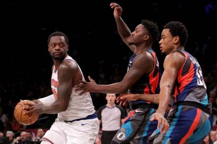 Dec 20, 2023; Brooklyn, New York, USA; New York Knicks forward Julius Randle (30) controls the ball against Brooklyn Nets forward Dorian Finney-Smith (28) and center Nic Claxton (33) during the first quarter at Barclays Center. Mandatory Credit: Brad Penner-USA TODAY Sports