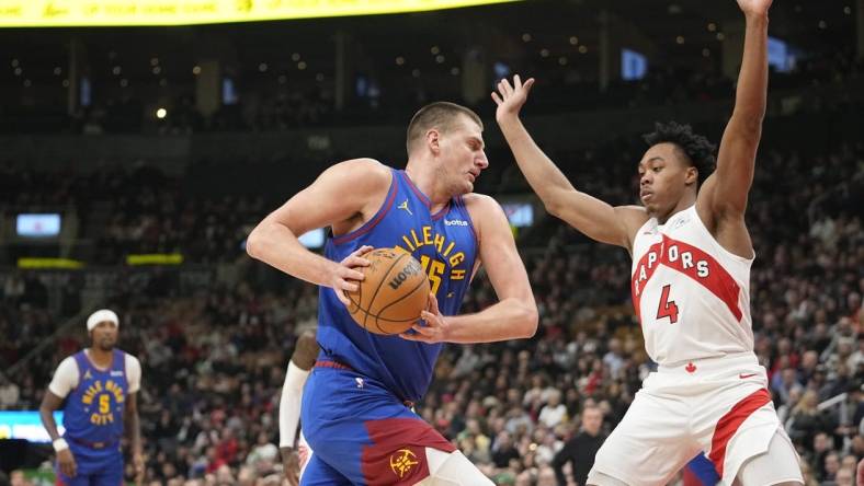 Dec 20, 2023; Toronto, Ontario, CAN; Denver Nuggets center Nikola Jokic (15) drives to the net against Toronto Raptors forward Scottie Barnes (4) during the first half at Scotiabank Arena. Mandatory Credit: John E. Sokolowski-USA TODAY Sports