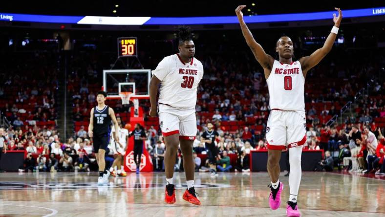 Dec 20, 2023; Raleigh, North Carolina, USA; North Carolina State Wolfpack guard DJ Horne (0) scores a three pointer and reacts with forward DJ Burns Jr. (30) during the second half against Saint Louis Billikens at PNC Arena. Mandatory Credit: Jaylynn Nash-USA TODAY Sports