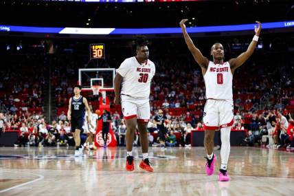 Dec 20, 2023; Raleigh, North Carolina, USA; North Carolina State Wolfpack guard DJ Horne (0) scores a three pointer and reacts with forward DJ Burns Jr. (30) during the second half against Saint Louis Billikens at PNC Arena. Mandatory Credit: Jaylynn Nash-USA TODAY Sports