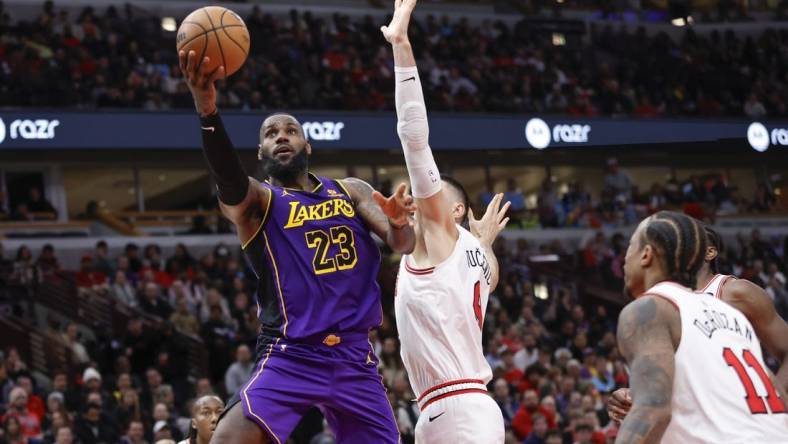 Dec 20, 2023; Chicago, Illinois, USA; Los Angeles Lakers forward LeBron James (23) goes to the basket against Chicago Bulls center Nikola Vucevic (9) during the second half at United Center. Mandatory Credit: Kamil Krzaczynski-USA TODAY Sports