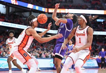 Dec 21, 2023; Syracuse, New York, USA; Syracuse Orange forward Benny Williams (13) has the ball hit his head on a drive by Niagara Purple Eagles guard Kwane Marble (12) with forward Maliq Brown (1) in the first half at the JMA Wireless Dome. Mandatory Credit: Mark Konezny-USA TODAY Sports