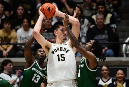 Dec 21, 2023; West Lafayette, Indiana, USA;  Purdue Boilermakers center Zach Edey (15) keeps the ball away from Jacksonville Dolphins guard Robert McCray V (13) and forward Stephon Payne III (0) right, during the first half at Mackey Arena. Mandatory Credit: Marc Lebryk-USA TODAY Sports