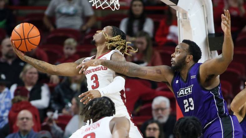 Dec 21, 2023; Fayetteville, Arkansas, USA; Arkansas Razorbacks guard El Ellis (3) shoots as Abilene Christian Wildcats forward Airion Simmons (23) defends during the first half at Bud Walton Arena. Mandatory Credit: Nelson Chenault-USA TODAY Sports