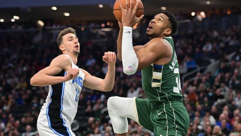 Dec 21, 2023; Milwaukee, Wisconsin, USA; Milwaukee Bucks forward Giannis Antetokounmpo (34) takes a shot against Orlando Magic forward Franz Wagner (22) in the first quarter at Fiserv Forum. Mandatory Credit: Benny Sieu-USA TODAY Sports