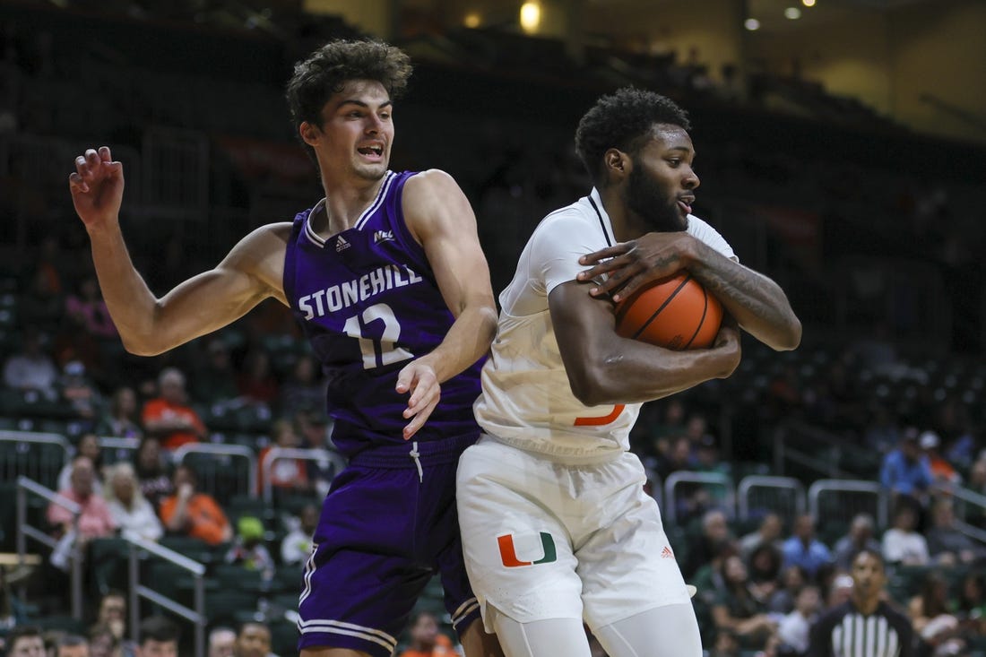 Dec 21, 2023; Coral Gables, Florida, USA; Miami Hurricanes guard Wooga Poplar (5) grabs a rebound against Stonehill Skyhawks guard Thatcher Stone (12) during the first half at Watsco Center. Mandatory Credit: Sam Navarro-USA TODAY Sports