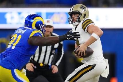 Dec 21, 2023; Inglewood, California, USA; New Orleans Saints quarterback Derek Carr (4) is sacked by Los Angeles Rams defensive tackle Kobie Turner (91) in the first half at SoFi Stadium. Mandatory Credit: Kirby Lee-USA TODAY Sports